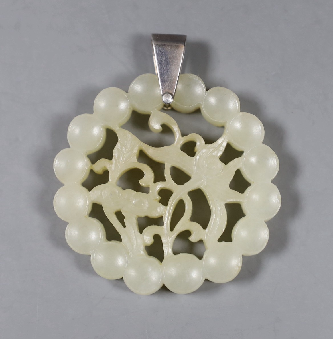 A Chinese carved circular jade pendant. 5.5cm diameter